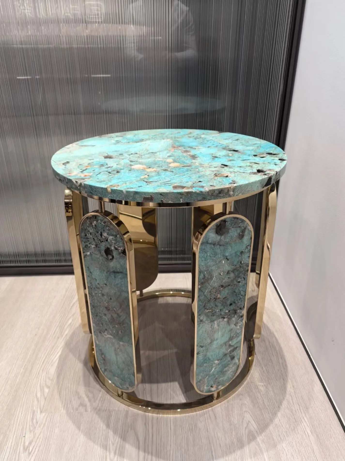 Bespoke side table combining polished metal and natural stone