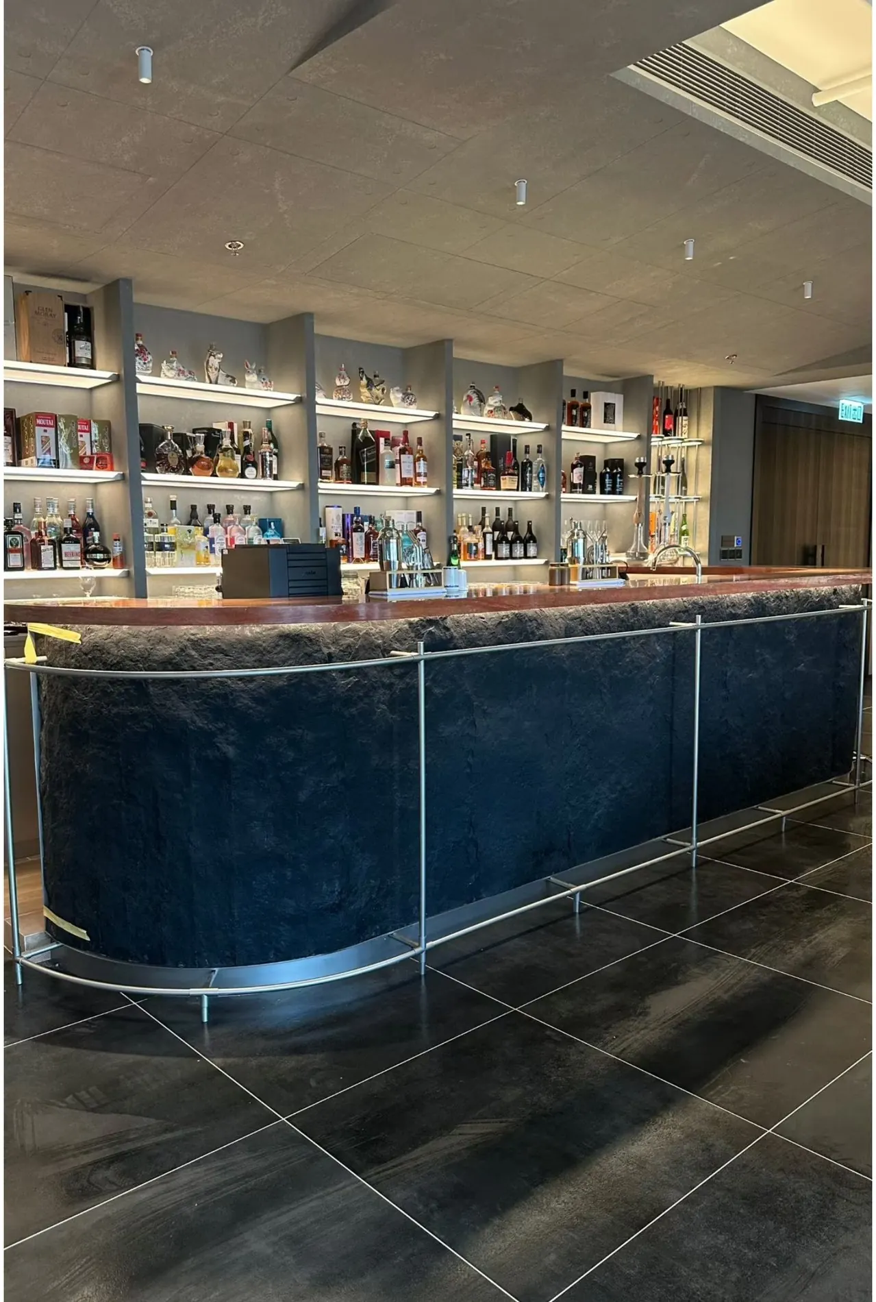 Curved custom bar with patinated panels and stainless steel detailing