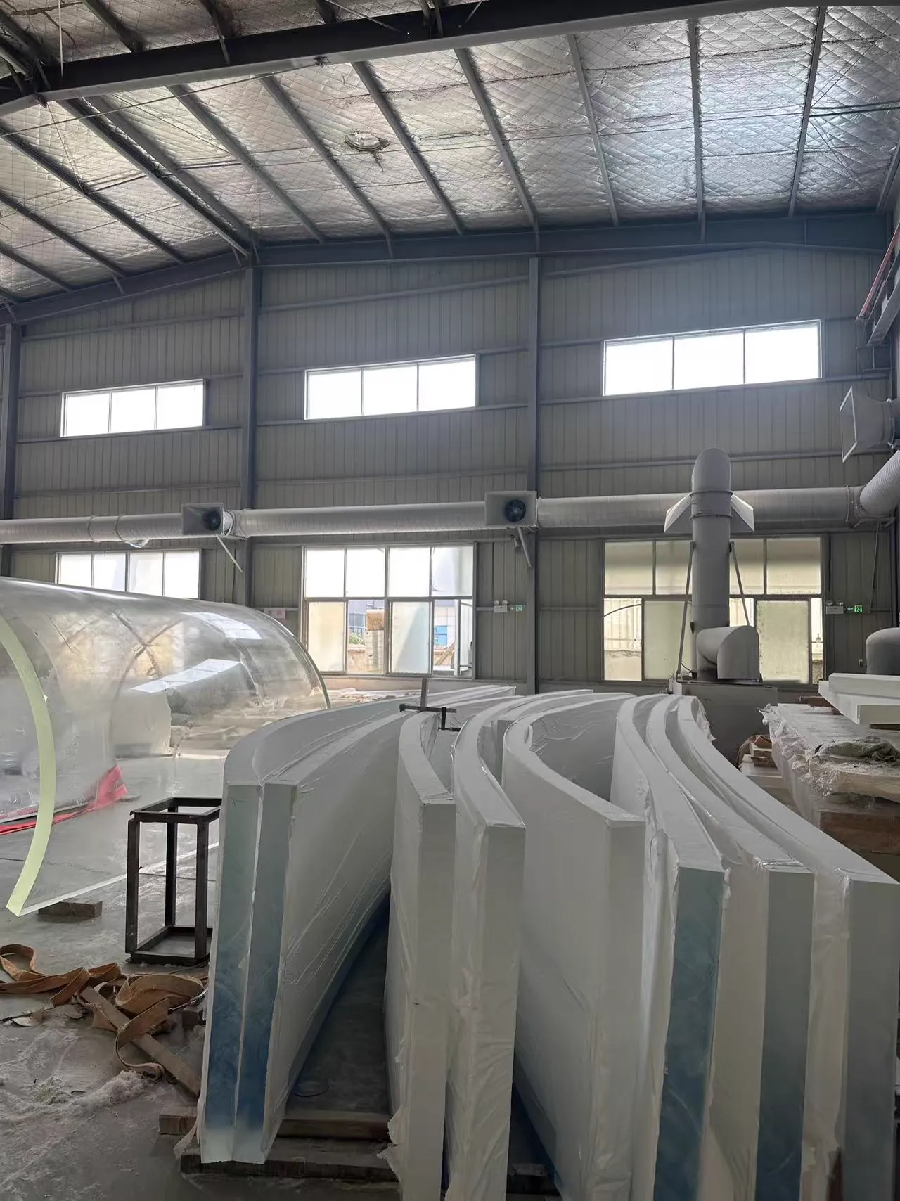Large curved acrylic components protected and staged inside the factory